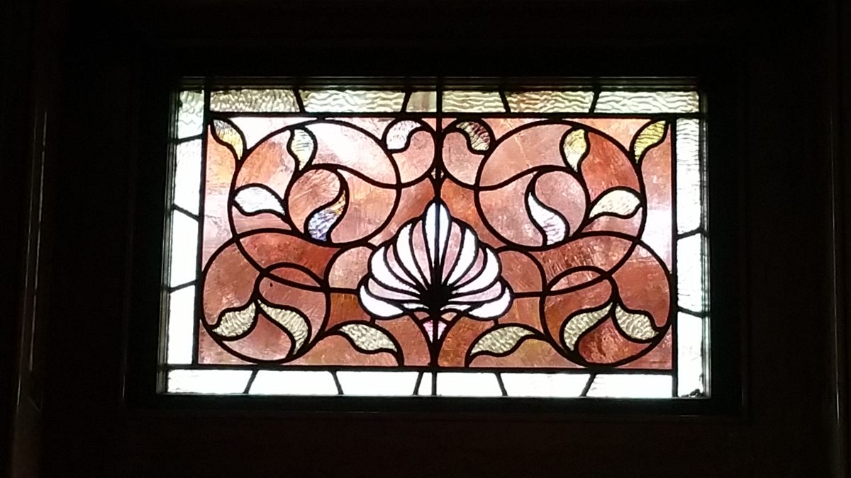 A single stained-glass transom panel in warm colours