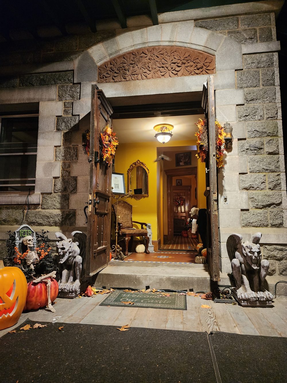 The open front door at Halloween with gargoyles and lanterns