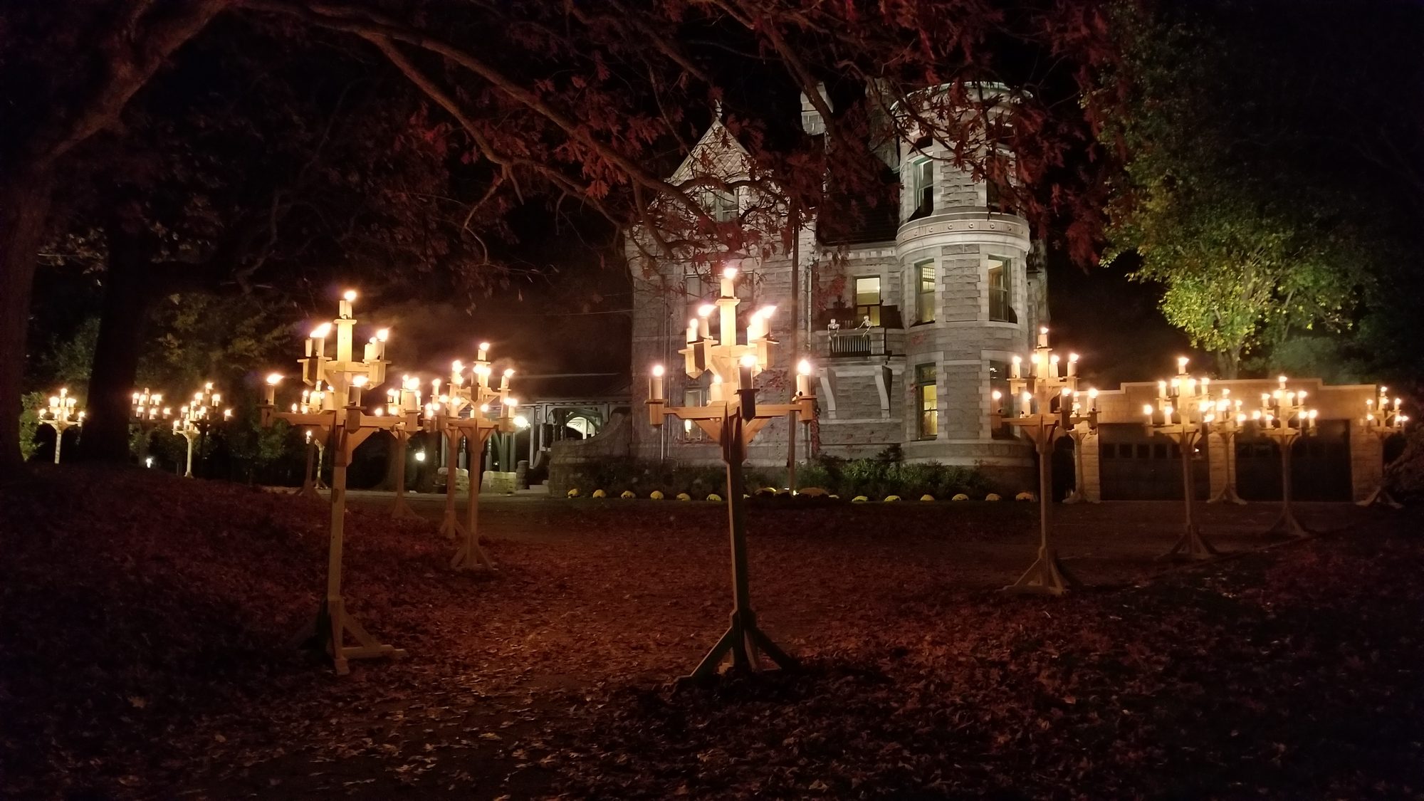 Nine-foot candelabras lit at night on the lawn, the castle floodlit behind them