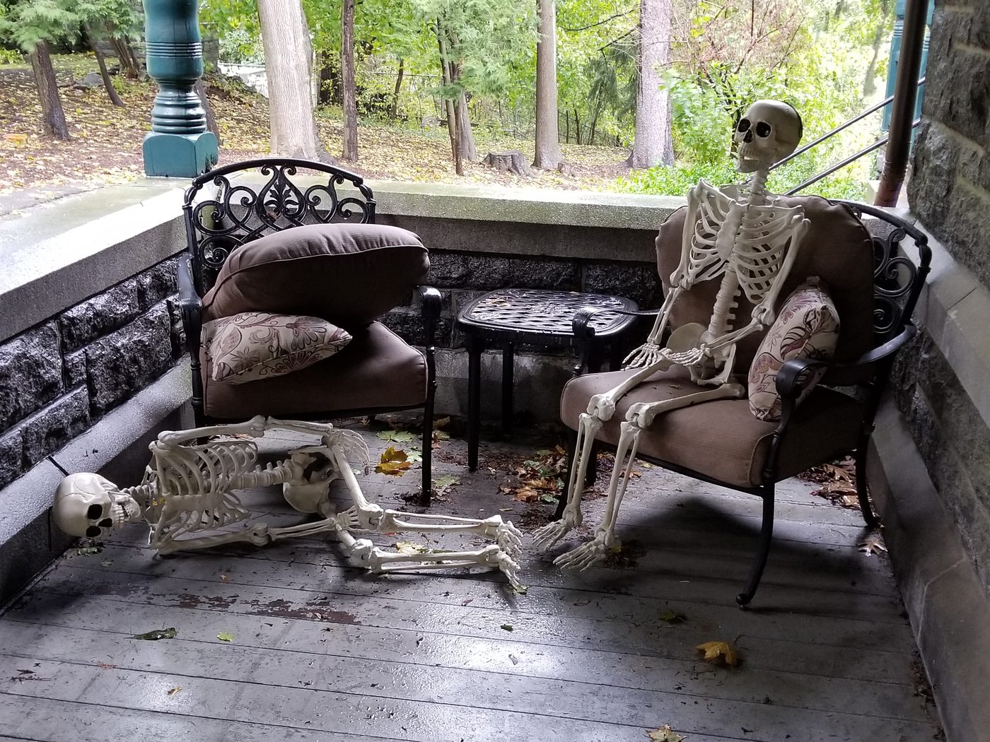 Skeletons seated on the porch furniture