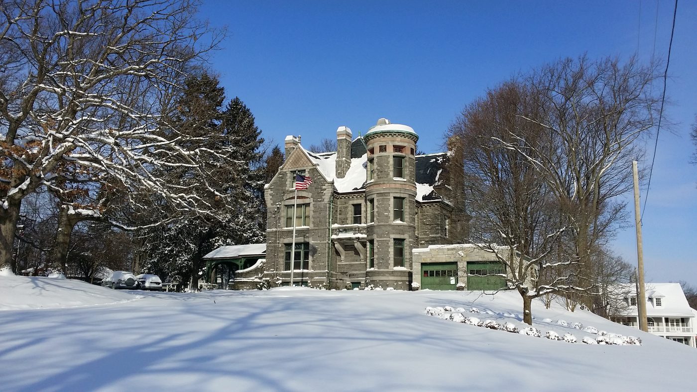 The front of the house in deep snow with the flag flying