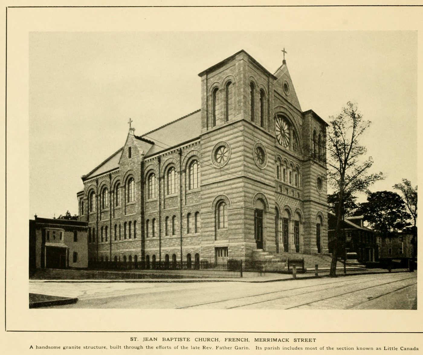 A large granite church with twin gables and a rose window at a street corner