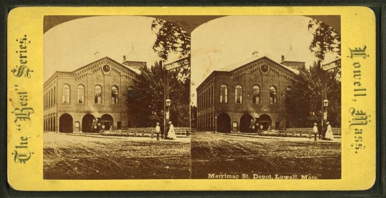 Stereograph of a brick railroad depot with arched openings and a carriage in front