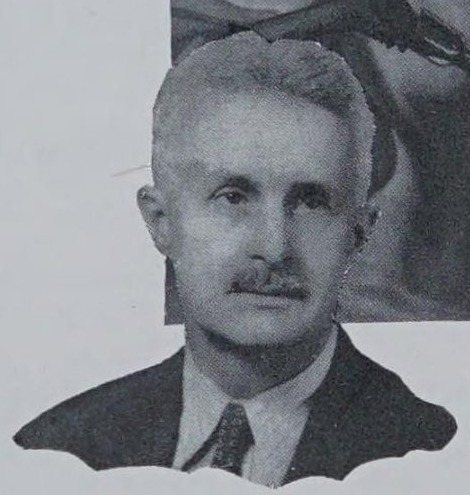 Halftone photograph of a gray-haired man with a mustache in a dark suit and tie, cut out against one of his paintings